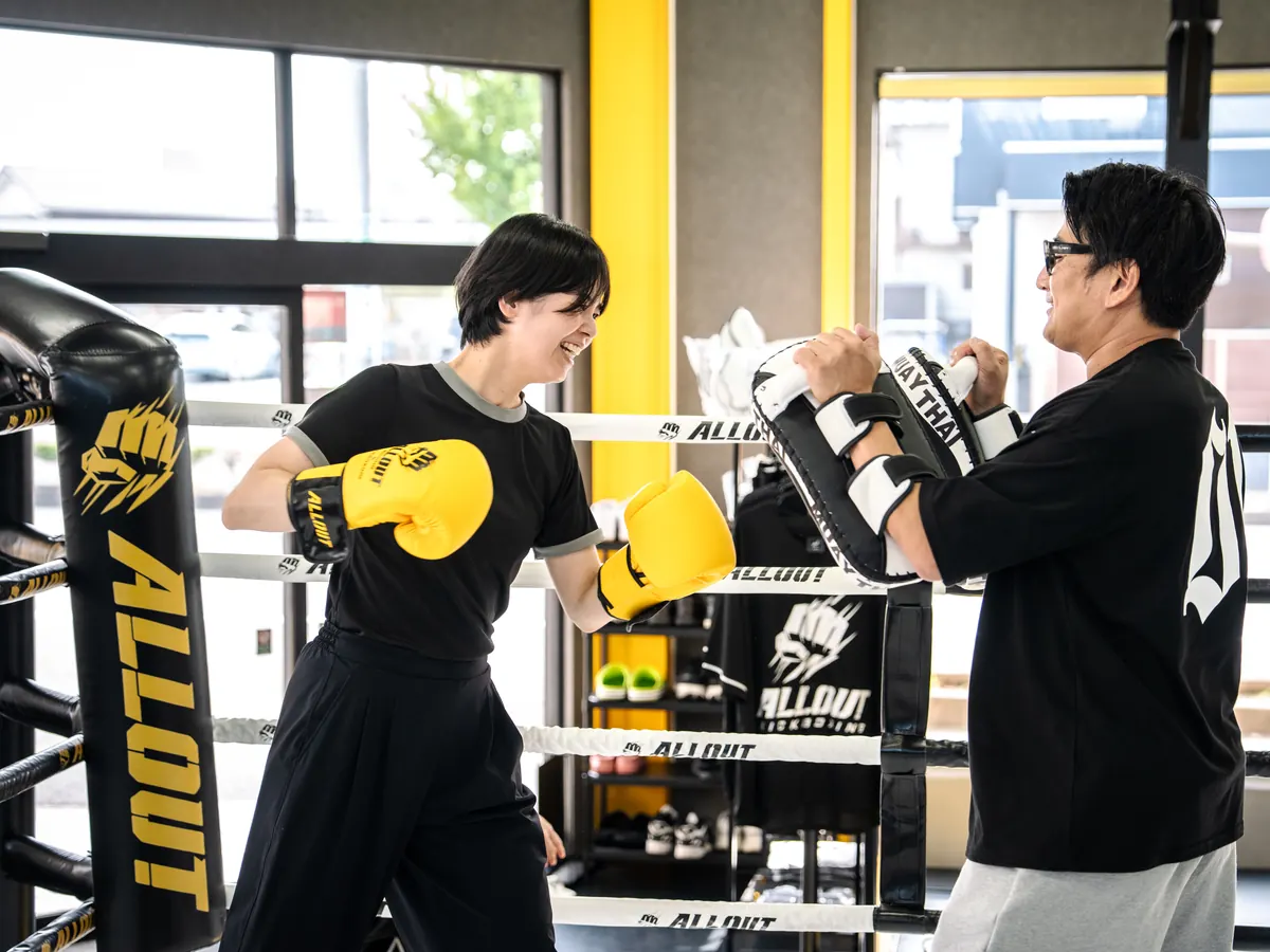 トレーナーとミット打ちをする女性会員